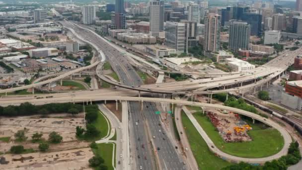 En avant drone volant vers énorme carrefour autoroutier à voies multiples en ville. Vue aérienne de la circulation aux heures de pointe. Inclinez-vous dans les détails de la construction de transports à plusieurs niveaux. Dallas, Texas, USA — Video