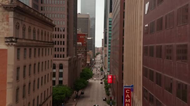 İHA, Elm Caddesi boyunca yüksek ticari binalar arasında uçuyor. Trafik yüzünden şehir merkezinin manzarası yükseldi. Dallas, Teksas, ABD — Stok video