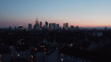 Mavi saatte İHA 'dan yükseltilmiş şehir manzarası. Gökdelenleri pembe mavi günbatımı gökyüzüne karşı olan şehir merkezi manzarası. Frankfurt am Main, Almanya