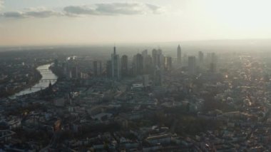 Şehir merkezindeki yüksek modern binaların havadan görünüşü. Şehirden geçen nehirde gökdelenleri olan bir şehir. Frankfurt am Main, Almanya