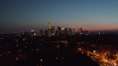 Geceleri şehir. Gün batımından sonra şehir merkezinin hava aracı panoramik görüntüsü. Aydınlatılmış gökdelenleri olan şehir manzarası. Frankfurt am Main, Almanya