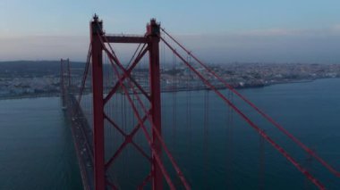 Büyük kırmızı Ponte 25 de Abril köprüsünün hava yörüngesinde Lizbon, Portekiz sahilinden geçen araba trafiği
