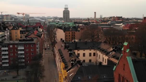 Низкий полет беспилотника над жилыми домами в городском районе. Рука строительного крана на расстоянии. Стокгольм, Швеция — стоковое видео