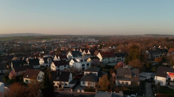 Küçük bir kasabanın panoramik hava manzarası ve çevre manzarası. Parlak akşam güneşiyle aydınlanan beyaz evler. Kötü Vilbel, Almanya. — Stok video