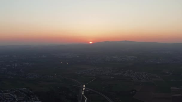 Hava akşam düz manzara manzarası. Güneş ufukta batıyor. Küçük bir kasabanın üzerinde uçan insansız hava aracının görüntüsü. Renkli alacakaranlık gökyüzü. — Stok video