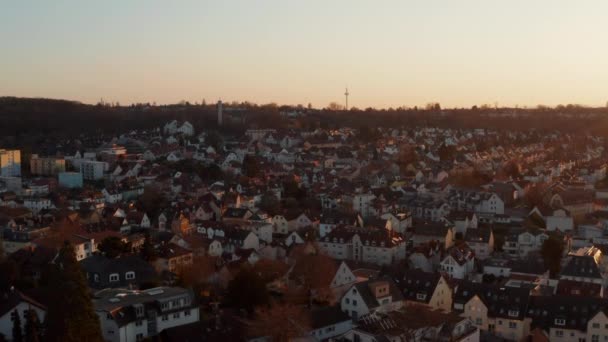 Aerial evening view of calm small spa town. Rising footage reveals Frankfurt am Main city skyline with skyscrapers on horizon. Bad Vilbel, Germany. — Stock Video