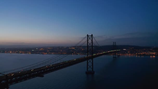 Vista aérea del tráfico de coches a través del mar sobre el puente rojo Ponte 25 de Abril en Lisboa, Portugal — Vídeo de stock