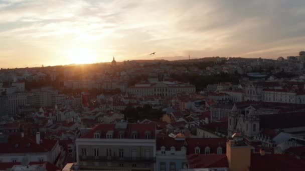 Vista aérea deslizante de telhados de casas europeias antigas coloridas no centro urbano de Lisboa, Portugal durante o pôr-do-sol — Vídeo de Stock