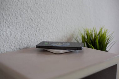 Aküyü şarj etmek için kablosuz şarj pedinde akıllı telefon