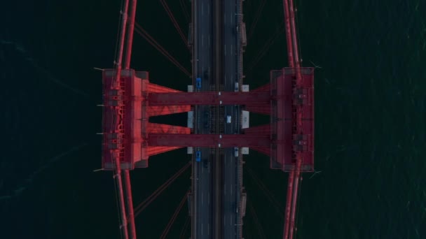 Aerial birds eye overhead top down view of cars driving on multilane road on suspension bridge against dark background. Abstracto, retira las imágenes. Efecto espejo. Lisboa, Portugal. — Vídeos de Stock