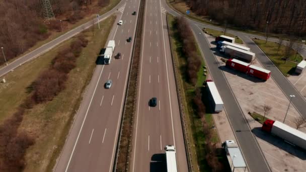 Hochgeklappt zeigt sich die schnurgerade Autobahn, die durch flaches Land zwischen Feldern führt. Flucht über Straße. Verkehrs- und Verkehrskonzept. — Stockvideo