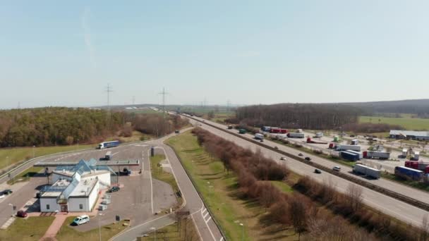 Fly across busy multilane highway Autobahn in Germany. Aerial view of cars and trucks driving on straight motorway. Traffic and transportation concept. — Stock Video