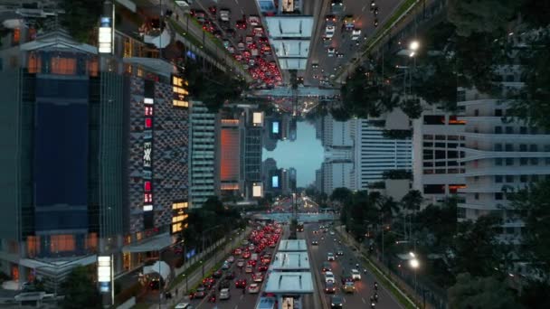 Revelar adelante de la calle concurrida en la hora punta de la tarde. Carretera de varios carriles con gran rotonda, bordeada de edificios modernos en el centro. Imágenes abstractas del efecto espejo. Yakarta, Indonesia. — Vídeos de Stock