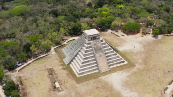 Eski Maya kasabasının havadan çekilmiş görüntüleri. Büyük taş tapınak piramidi ve birkaç küçük bina. Kolomb öncesi dönemin tarihi anıtları, Chichen Itza, Meksika. — Stok video