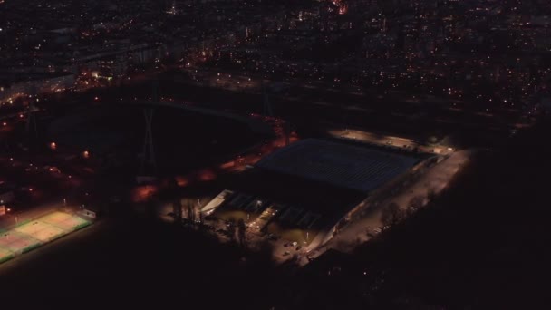 在体育场、现代大厅和足球场周围飞行.夜间城镇的空中录像。德国柏林. — 图库视频影像