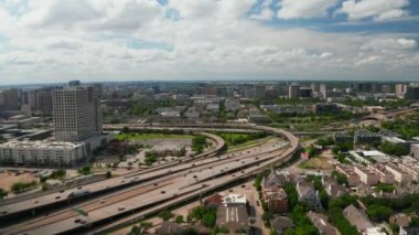 İleri uçar ve kasabadaki yoğun otoyol kavşağının görüntülerini aşağı indirir. Arabalar çok katlı ulaşım inşaatında sorunsuz bir şekilde ilerliyor. Dallas, Teksas, ABD.