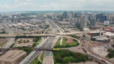 İleride geniş bir çok şeritli otoyol kavşağı görünüyor. Trafiğin yoğun olduğu saatte şehrin hava görüntüsü. Dallas, Teksas, ABD.