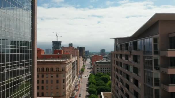 Vorne sind verschiedene Gebäude rund um die Innenstadt zu sehen. Der Abstieg fliegt über die Straße. Dallas, Texas, USA. — Stockvideo