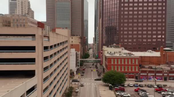 Voorwaarts onthullen van straat tussen hoge moderne gebouwen in het centrum. Vlieg boven de weg met weinig verkeer. Dallas, Texas, Verenigde Staten. — Stockvideo