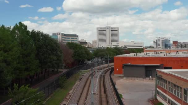 Voorwaarts vliegen boven lege geëlektrificeerde dubbelsporige spoorlijn die door de stad leidt. Dallas, Texas, Verenigde Staten. — Stockvideo