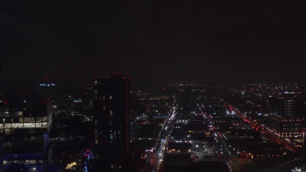 Вечерняя воздушная сцена города. Вперед, летим в район вечеринок Дип Эллум. Городские огни указывают направление улиц. Даллас, Техас, США. — стоковое видео