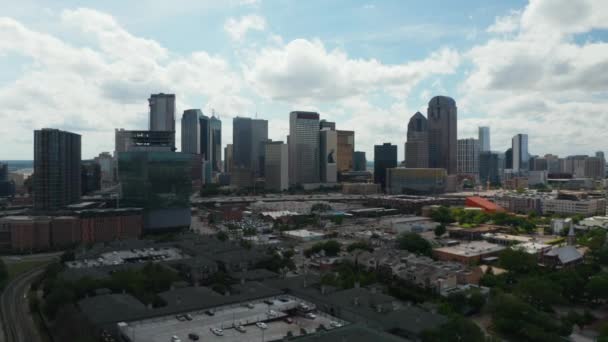 Panoramautsikt över centrum skyskrapor bakom rusa motorvägen. Framåt flyger över låga byggnader. Visa mot ljusa moln på himlen. Dallas, Texas, USA. — Stockvideo