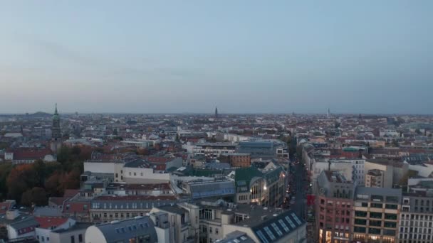 Forwards reveal of urban neighbourhood at dusk. Fly above various buildings in town. Berlin, Germany. — Stock Video