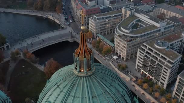 Een baan om de koepel met religieus kruis. Luchtfoto van de rivieroever en brug over de Spree achter het dak van de Berlijnse kathedraal. Berlijn, Duitsland. — Stockvideo