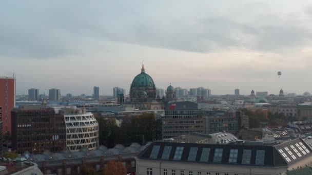 Adelante sobrevolando edificios modernos cerca de la Catedral de Berlín. Iglesia antigua con gran techo de cúpula. Berlín, Alemania. — Vídeo de stock