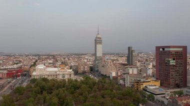 İleri, şehir parkının üzerinden Torre Latinoamericana yüksek binasına doğru uçuyor. Arka planda şehir manzarası. Mexico City, Meksika.