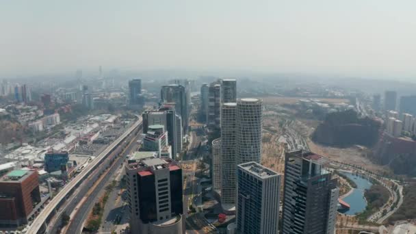 Hoge hoek uitzicht op een groep hoge wolkenkrabbers in het moderne Santa Fe stadsdeel gelegen tussen multilane weg en openbaar park. Mexico City, Mexico. — Stockvideo