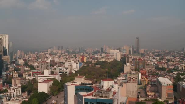 Lentamente in avanti rivelando parco cittadino circondato da abitazioni urbane. Skyline con grattacieli sullo sfondo. Città del Messico, Messico. — Video Stock