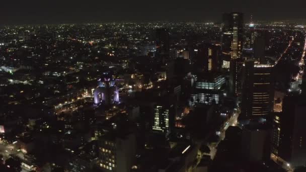 Aerial night scenic view of cityscape. Backwards reveal of illuminated streets and skyscrapers. Night life in town. Mexico City, Mexico. — Stock Video