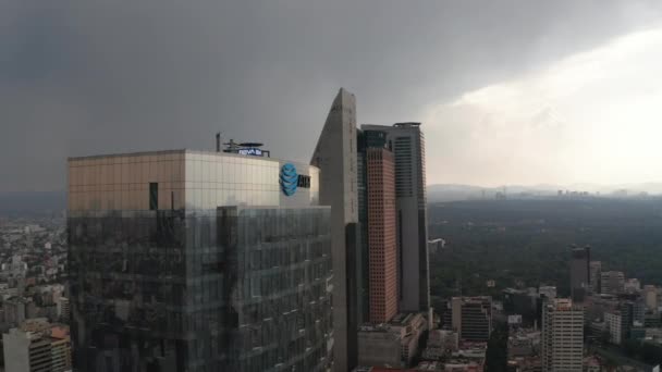 Volar alrededor de la parte superior de la oficina de vidrio edificio moderno. Vista panorámica del paisaje urbano. Dramático cielo nublado antes de fuertes lluvias. Ciudad de México, México. — Vídeo de stock