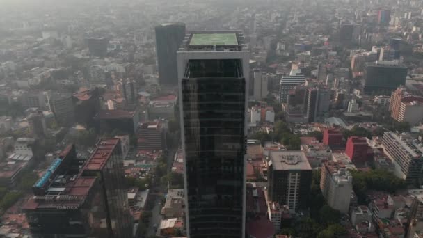 Fly over tall office building Tilt down to shot of heliport on roof of skyscraper. Mexico City, Mexico. — Stock Video