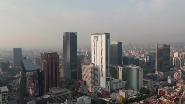 Panorama curva tiro do centro da cidade. A voar em direcção a edifícios de escritórios altos. Visibilidade limitada devido à poluição atmosférica. Cidade do México, México. — Vídeo de Stock