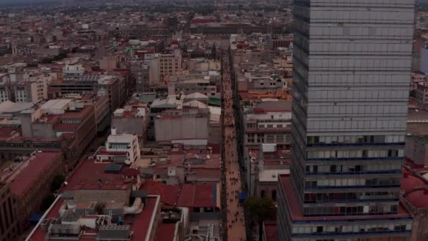 Lentamente hacia adelante vuelan por encima de la gente caminando por la calle. Disparo inclinado. Vista aérea de la vida de la ciudad. Ciudad de México, México. — Vídeo de stock