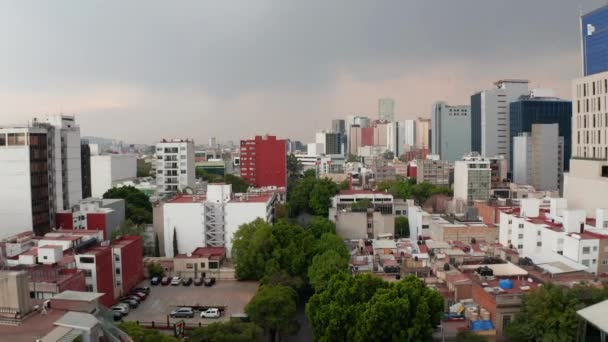 Alzati sopra basse case residenziali vicini con alti edifici per uffici. Cielo nuvoloso prima della pioggia o della tempesta. Città del Messico, Messico. — Video Stock