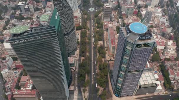 Vista inclinada hacia abajo de las carreteras de varios carriles que conducen entre los rascacielos del centro. Vista aérea de edificios altos con helipuertos en la azotea. Ciudad de México, México. — Vídeo de stock