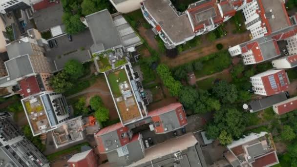 Aerea occhio uccelli sopra dall'alto verso il basso panning vista quartiere urbano. Sorvolando edifici, parchi, corti cittadine e strade. Berlino, Germania. — Video Stock