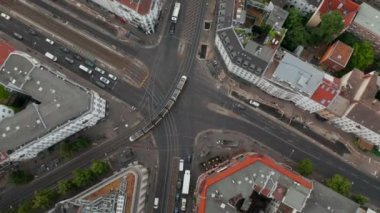 Tramvayın hava görüntüsü Rosenthaler Platz 'daki kavşaktan geçiyor. Yukarı kaldır ve Fernsehturm TV kulesi ile şehir manzarasını göster. Berlin, Almanya.