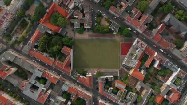 Vogelbeobachtung von oben nach unten Blick auf das Stadtviertel mit Fußballplatz. Aufsteigende Aufnahme von Straßen mit Gebäuden. Berlin, Deutschland. — Stockvideo