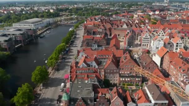 Luchtfoto 's van historische bakstenen huizen, brede rivierstraat en Trave rivier. Luebeck, Sleeswijk-Holstein, Duitsland — Stockvideo