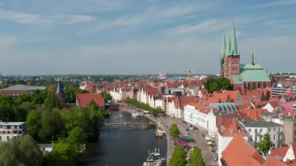 Imágenes descendentes de Trave frente al mar con botes amarrados, terrazas de restaurantes y gente caminando a lo largo del río. Centro histórico de la ciudad. Luebeck, Schleswig-Holstein, Alemania — Vídeos de Stock