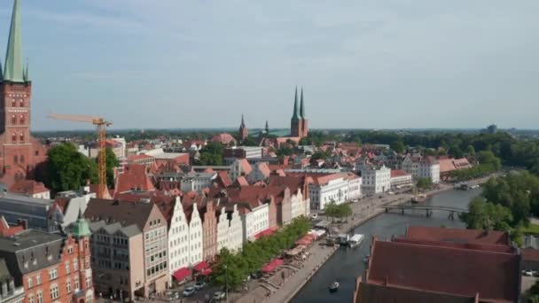 Voorwaarts onthullen van de huizen aan de brede waterkant. Uitzicht vanuit de lucht op het historische stadscentrum. Vlieg naar Luebeck kathedraal. Luebeck, Sleeswijk-Holstein, Duitsland — Stockvideo