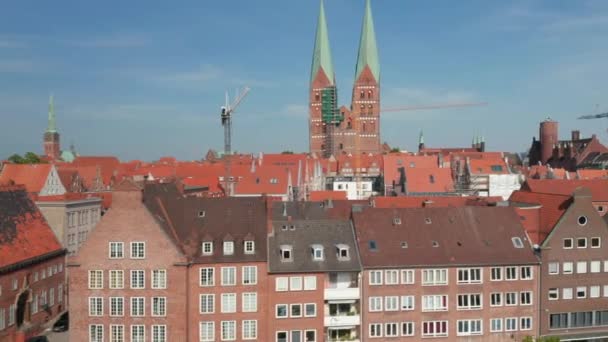 Przesuwne ujawnienie średniowiecznego centrum miasta. Budynki z czerwonej cegły z dachami z czerwonego kafelka. Dwie wysokie wieże kościoła św. Marii. Luebeck, Szlezwik-Holsztyn, Niemcy — Wideo stockowe