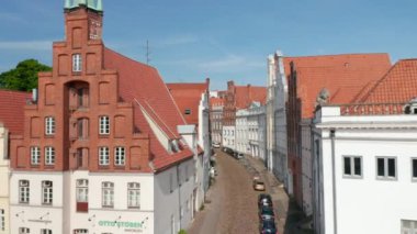 Ortaçağ şehir merkezinde tarihi virajlı sokaklar boyunca ilerliyorlar. Güzel ve bakımlı yüzleri olan eski evler. Luebeck, Schleswig-Holstein, Almanya