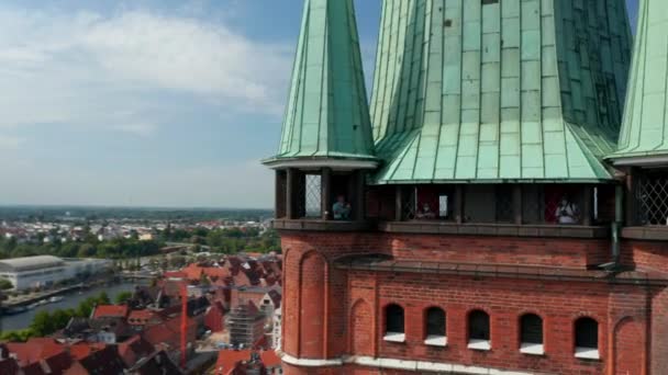 聖ペテルス教会のレンガ造りの塔で展望テラスを飛び回ってください。セントメアリーズ教会と中世の町の中心部の空中ビュー。ドイツのシュレースヴィヒ=ホルシュタイン州ルーベック — ストック動画