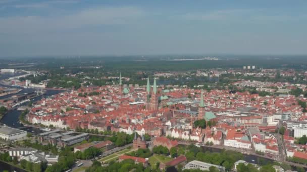 Panoramisch uitzicht vanuit de lucht op het middeleeuwse stadscentrum, omzoomd met de rivier Trave. Holsten Gate, St. Marys, St. Peters en St. Jacobs kerken. Luebeck, Sleeswijk-Holstein, Duitsland — Stockvideo