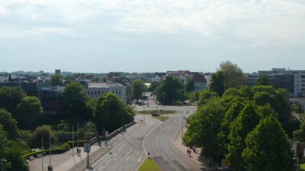 Forwards reveal of roundabout. Aerial view of main road with low traffic leading through town. Luebeck, Schleswig-Holstein, Germany — Stock Video